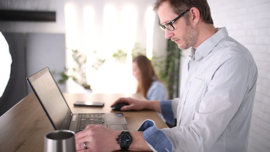 man in blue dress shirt using computer